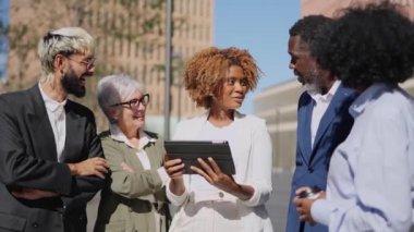 Finans bölgesinde tablet kullanan güler yüzlü iş adamlarının videosu.