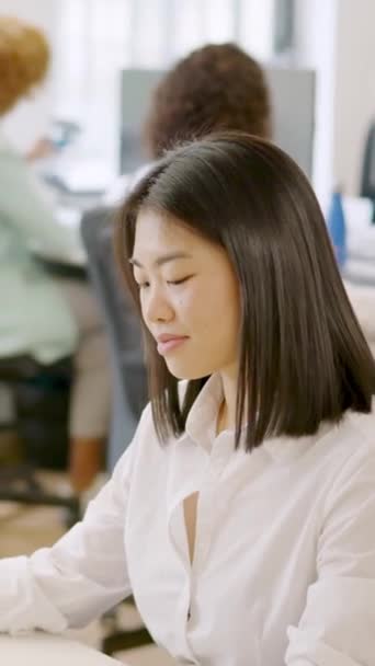 一个亚洲女人和其他同事在一个愉快的工作环境中工作的慢动作视频 — 图库视频影像