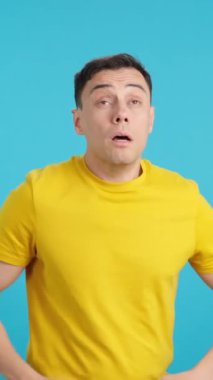 Stüdyoda, arka arkaya beş kez hapşıran bir adamın mavi arka planlı videosu var.