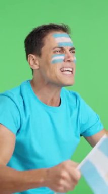 Stüdyoda, elinde Arjantin bayrağı sallayan, hakemlerin kararına kızgın bir adamın krom görüntüsü var.