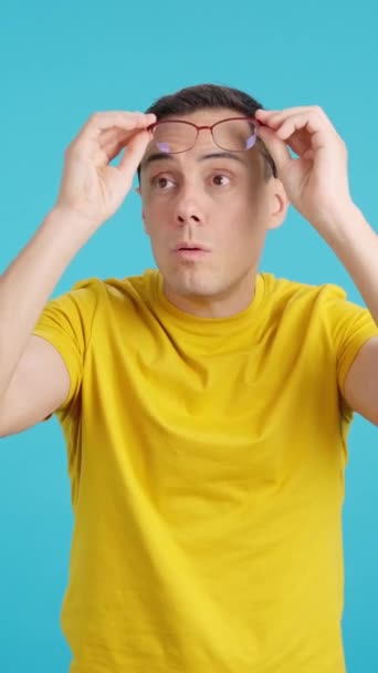 Stüdyoda Mavi Arka Planı Olan Mutlu Bir Adam Gözlüğünü Çıkarıyor — Stok video