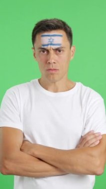 Stüdyoda, yüzünde İsrail bayrağı olan, ağırbaşlı ve ciddi bir adamın rengiyle kameraya haysiyetle bakan görüntüler var.