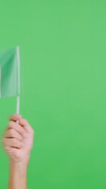 Stüdyoda, İtalya bayrağının bayrağını sağa sola sallayan bir elin kromasıyla yavaş çekim videosu.