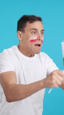 Stüdyoda, elinde Polonya bayrağı sallayan, hakemlerin kararına kızgın bir adamın krom görüntüsü var.