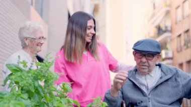 Şefkatli bir bakıcının videosu endişeli yaşlı bir adamla konuşuyor ve neşelendiriyor.