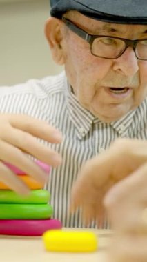 Geriatri 'de bir yetenek oyununun parçalarını düzenleyen iki yaşlı insanın videosu.
