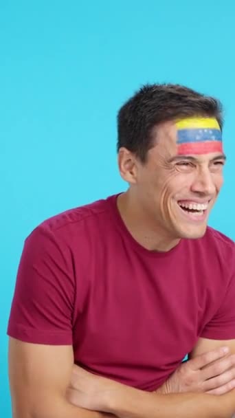 空白のコピースペースに目を向けて顔に描かれたベネズエラの旗を持つ幸せな男のクロマとスタジオでのビデオ — ストック動画