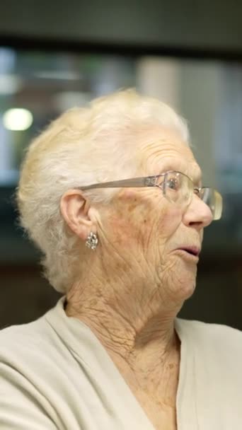 Zbliżenie Wideo Starszej Kobiety Uśmiechniętej Kamery Siedzącej Domu Opieki — Wideo stockowe