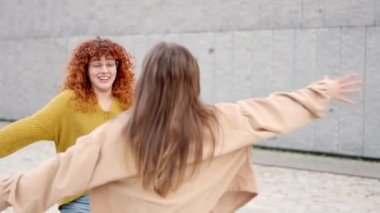 Sokakta iki genç arkadaşın mutlu buluşması sırasında sarılan iki kadının yavaş çekim videosu.