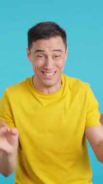 Stüdyoda, sürekli kameraya konuşan ve yalnız kalan çok sinir bozucu bir adamın mavi arka planlı videosu var.