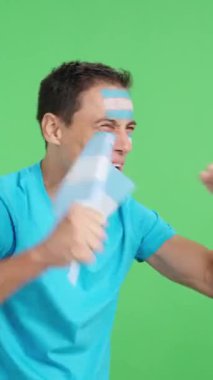 Stüdyoda Arjantin 'e tezahürat yapan, çığlık atan ve elinde ulusal bir bayrak sallayan, boş bir şekilde fotokopi odasına bakan bir adamın kromasıyla.