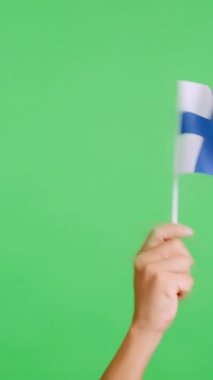Stüdyoda, Finlandiya bayrağının bayrağını sağa sola sallayan bir elin kromasıyla yavaş çekim videosu