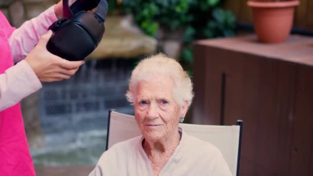 Видео Медсестры Надевающей Очки Виртуальной Реальности Пожилой Женщины Саду Дома — стоковое видео