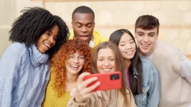 Çeşitli gençlerden oluşan yavaş çekim videosu. Selfie çekiyorlar, gülümsüyorlar ve dışarıda gülüyorlar.