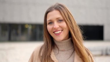 Dışarıda kameraya gülümseyen genç bir kız öğrenciye yaklaşan kamerayla yavaş çekim videosu.