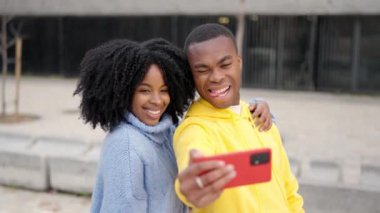 Şehir parkında selfie çeken Afrikalı bir çiftin yavaş çekim videosu.
