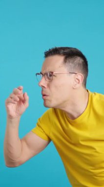 Stüdyoda bir adamın mavi arkaplanlı videosu boş boşluğu göremiyor ve gözlüklerini ayarlıyor. Gördüğünü görünce şaşırıyor..