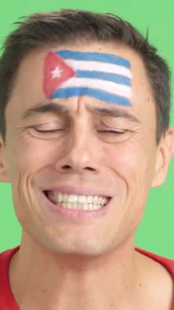 在演播室里用彩色拍片 画面中一个非常紧张的男人 脸上涂满了古巴国旗 在一场最后以失败告终的艰难的比赛中 他支持古巴队 — 图库视频影像
