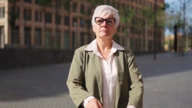 Yetişkin bir iş kadınının sokakta el ele tutuşmasının videosu.