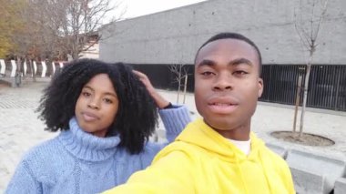 Erkek arkadaşıyla dışarıda fotoğraf çektirmek için saç düzenleyen Afrikalı bir kadının videosu.