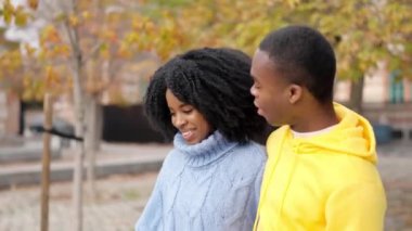 Genç bir Afrikalı çiftin sokakta yürürken flört edişinin yavaş çekim videosu.