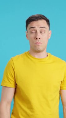 Stüdyoda, kendisine sunulan teklifleri göz ardı ederek alay eden bir adamın mavi arka planlı videosu var..