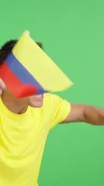 摄影棚里的录像 彩色的是一个男人为哥伦比亚欢呼 挥舞着国旗 无声无息地看着复制的空间 — 图库视频影像