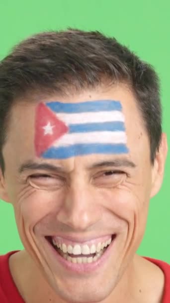 摄影棚里的录像 彩色的是一个男人的特写 脸上挂着古巴国旗 在镜头前微笑 — 图库视频影像