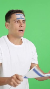 Stüdyoda, gergin bir adamın İsrail için tezahürat yaptığı heyecanlı bir maçın krom görüntüsü var.