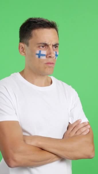 Видео Студии Хромой Человека Финским Флагом Нарисованным Лице Серьезным Выражением — стоковое видео