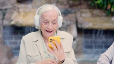 Yaşlı bir kadının yaşlı bir kadınla video görüşmesi için telefon kullanmasının videosu.