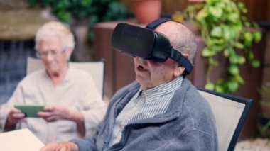 Bahçede oturan teknolojiyi kullanan üç yaşlı insanın videosu.