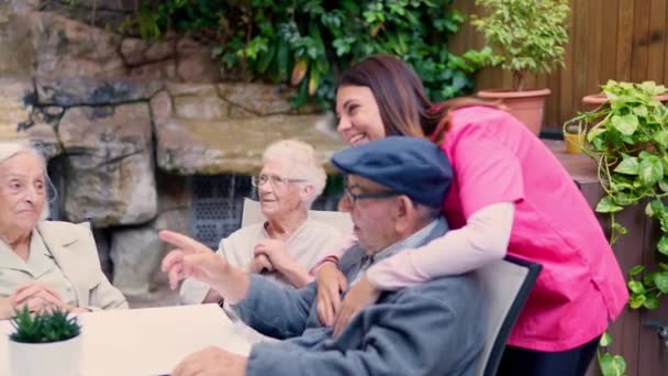 看護師と高齢者のビデオ 話すと高齢者の庭で笑う — ストック動画