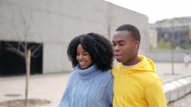 Sokakta yürürken konuşan mutlu bir Afrikalı çiftin yavaş çekim videosu.