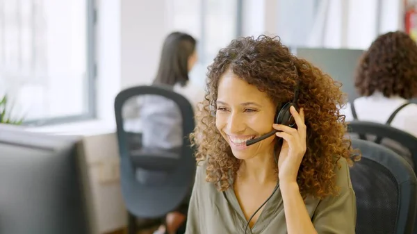 Telephone operator answering the phone with a smile in a coworking space