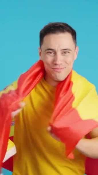 Видео Студии Синим Фоном Счастливого Человека Обернутого Испанским Национальным Флагом — стоковое видео
