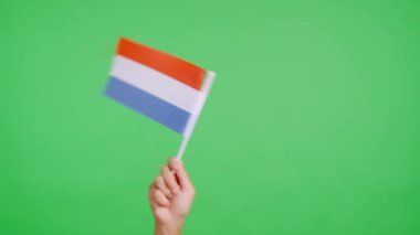 Hollanda bayrağının bayrağını sağa sola sallayan bir elin krom rengiyle stüdyoda yavaş çekim videosu
