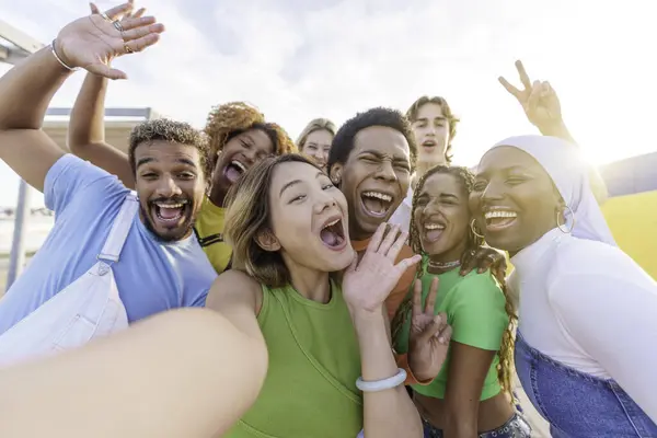 Ecstatic chinese woman taking selfie with multiethnic friends outdoors