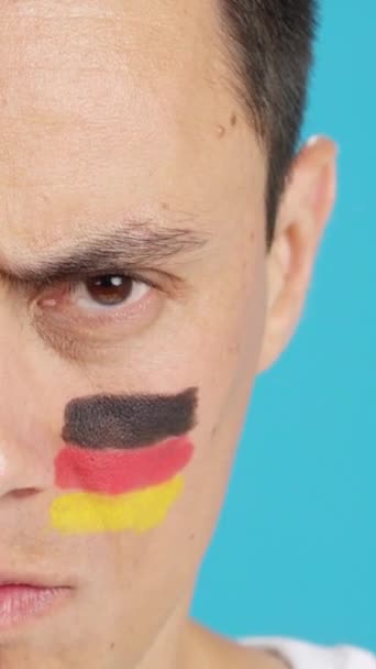 カメラを見ている顔にドイツの旗を塗った深刻な男のクローマのスタジオでのビデオ — ストック動画