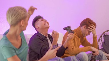 Evde arkadaşlarıyla konsol oynayarak kazanan İspanyol bir adam.