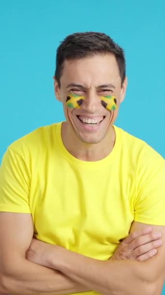 Відео Студії Хромою Чоловіка Стоїть Ямайським Прапором Намальованим Обличчі Посміхаючись — стокове відео