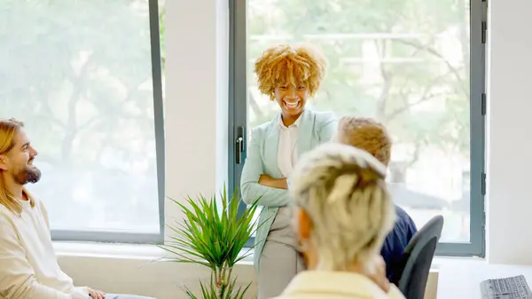 Happy african businesswoman smiling in a meeting with coworkers