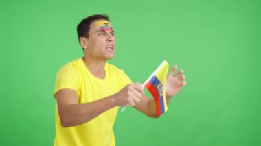 Ekvador ulusal bayrağını sallayan, hakemlerin kararına kızgın bir adamın kromasıyla stüdyoda bir video.
