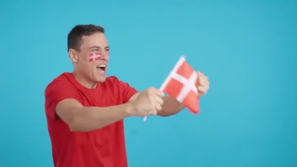 摄影棚里的录像 彩色的是一个男人在为丹麦欢呼 挥动着国旗 无声无息地看着复制的空间 — 图库视频影像
