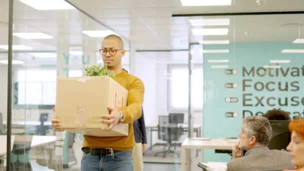 上司の水平なスローモーションビデオは 持ち物を含む箱を持つ解雇された従業員への出口を指示します — ストック動画