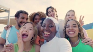 Afrikalı Müslüman bir kadının çok ırklı arkadaşlarıyla dışarıda selfie çektiği yavaş çekim videosu.