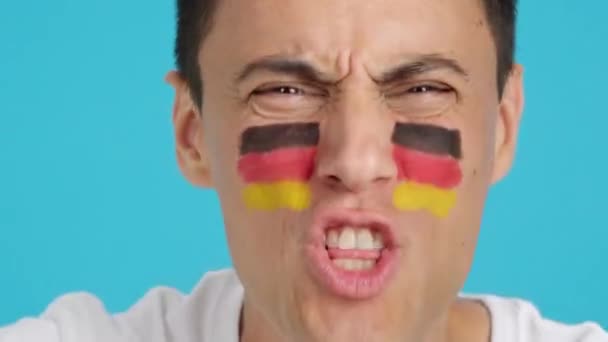 ドイツのチームをサポートする顔にドイツの旗を塗った男のクロマのスタジオでのビデオ — ストック動画