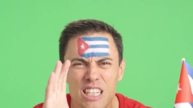 Küba ulusal bayrağı taşıyan bir adam hakeme kızgın.