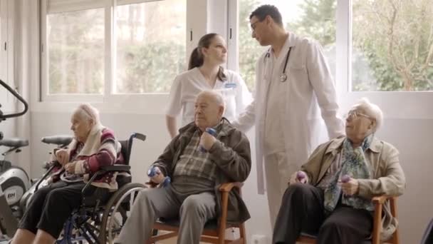 Vídeo Cámara Lenta Dos Médicos Distraídos Hablando Mientras Personas Mayores — Vídeo de stock