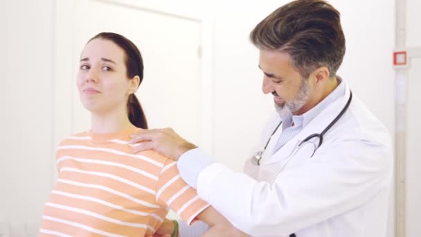 一个成熟的医生在诊所检查一个女人疼痛的背部的慢镜头 — 图库视频影像